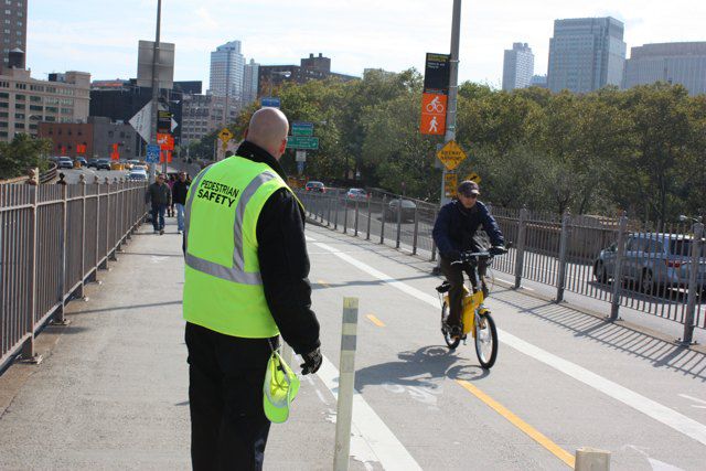 A pedestrian safety manager does his thing on the Brooklyn Bridge